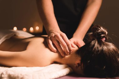 Mens el masaj bir masaj koltuğu masaj Spa karanlık aydınlatma ile yatan bir kız için bir tedavi boyun yapacaklar. Yakın çekim. Karanlık anahtar