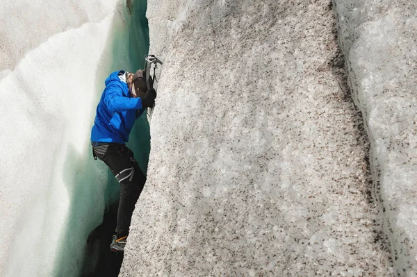 一个没有保险的自由登山者从冰川上的裂缝中升起。自由攀登没有绳索 — 图库照片