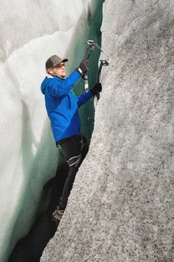 İki Buz baltaları ile sigorta olmadan ücretsiz bir dağcı buzulun bir boşlukta üzerinden yükselir. Ücretsiz halat tırmanma