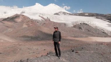 arial görünümü bir uçurumun bir kap ve karla kaplı Kafkas Dağları ve Elbruz Dağı çevrili güneş gözlüğü üzerinde duran bir adam etrafında uçan