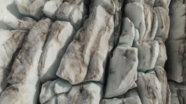 Yakın çekim düşük uçuş 4 k dağlık sürünen buzulun derin çatlaklar üzerinden. Buzul sarı volkanik kum ile toz