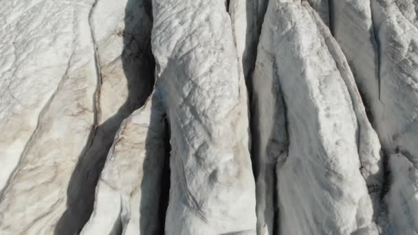 Nahaufnahme-Tiefflug über die tiefen Risse eines bergigen Kriechgletschers in 4k. Gletscher mit gelbem Vulkansand gepudert — Stockvideo