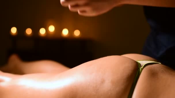 Primer plano de un hombre. Las manos de un masajista en un spa hacen masajes con golpes ligeros a una mujer joven. El concepto de cuidado y belleza. Prevención de la celulitis en las nalgas — Vídeo de stock