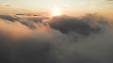 Bulutlara aracılığıyla dusk veya şafak uçan. Pembe bulutlar güneşin uçan. Havadan görünümü. Kuzey Kafkasya