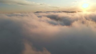 Bulutlara aracılığıyla dusk veya şafak uçan. Pembe bulutlar güneşin uçan. Havadan görünümü. Kuzey Kafkasya