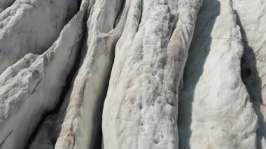 Yakın çekim düşük uçuş 4 k dağlık sürünen buzulun derin çatlaklar üzerinden. Buzul sarı volkanik kum ile toz