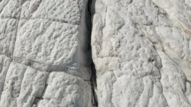 Yakın çekim düşük uçuş 4 k dağlık sürünen buzulun derin çatlaklar üzerinden. Buzul sarı volkanik kum ile toz