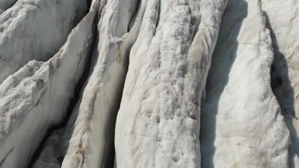 Närbild låg flygning över djupa sprickor i en bergig krypande glaciär i 4k. Glaciären pulverform med gula vulkanisk sand — Stockvideo