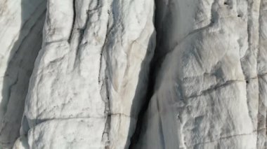 Yakın çekim düşük uçuş 4 k dağlık sürünen buzulun derin çatlaklar üzerinden. Buzul sarı volkanik kum ile toz