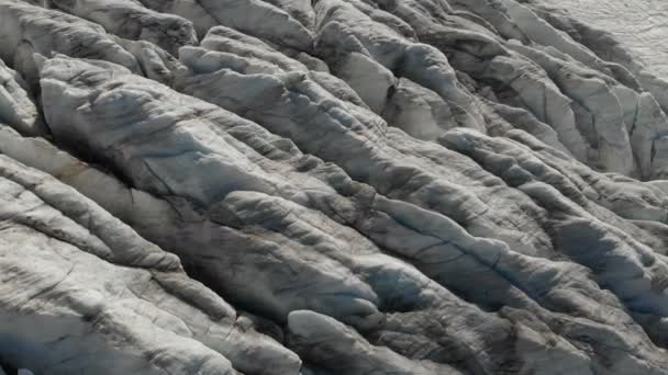 Close-up lav flyvning over de dybe revner i en bjergrig snigende gletsjer i 4K. Glacier pulveriseret med gult vulkansk sand – Stock-video