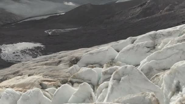 Primo piano volo basso sulle profonde crepe di un ghiacciaio montuoso strisciante in 4K. Ghiacciaio in polvere con sabbia vulcanica gialla — Video Stock