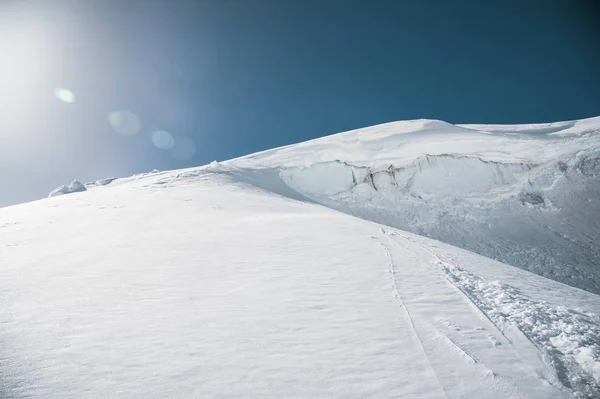 Slunce nad zimní hory pokryté sněhem. Nedotčené freeride svah. Zasněžené ledovec — Stock fotografie