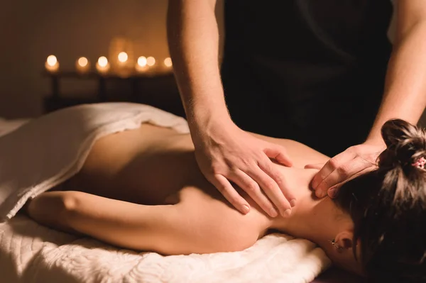 Nahaufnahme eines männlichen Handarbeiters bei einer Wellness-Massage für ein junges Mädchen in einem dunklen Raum — Stockfoto