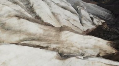 Yakın çekim düşük uçuş 4 k dağlık sürünen buzulun derin çatlaklar üzerinden. Buzul sarı volkanik kum ile toz