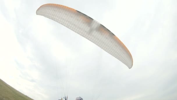 Профессиональный пилот парапланеристов среднего класса готовится к взлету поднимает крыло и идет с поднятым по парадрому крылом — стоковое видео