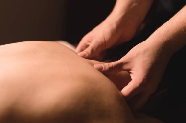 Mens el masaj bir masaj koltuğu masaj Spa karanlık aydınlatma ile yatan bir kız için bir tedavi boyun yapacaklar. Yakın çekim. Karanlık anahtar