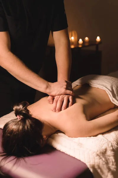 Close-up van mannelijke arbeider Wellness massage aan een jong meisje in een donkere kamer doen — Stockfoto