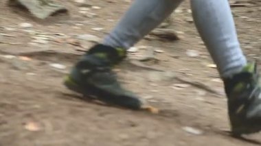 İnce kız iğne yapraklı orman yol boyunca yürüyüş. Turizm Caucasus yedekte. Bir turist ayak closeup. Kameranın doğru gider