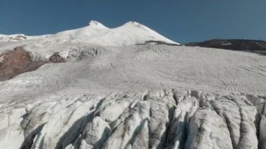 Arial görünümü buzullar üzerinde uyuyan Elbrus volkan. Dikey kamera hareketi. Kuzey Kafkasya Rusya