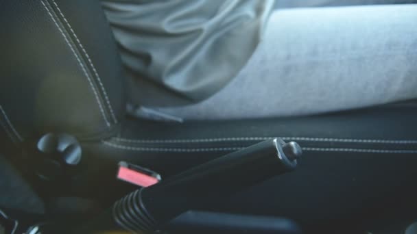 Il primo piano di ragazza di azione attacca una cintura di sicurezza in un'auto prima di scendere. Concetto guida sicuro — Video Stock