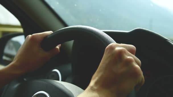Close-up op open diafragma. Het meisje rijdt een auto op een landweg. Womens handen op het stuurwiel — Stockvideo