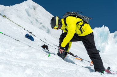 Bir buzulun üzerinde duran bir profesyonel kayakçı kayak ekipmanları ayarlanırken bir sıçrama için hazırlanıyor. Spor için kaliteli eğitim kavramı