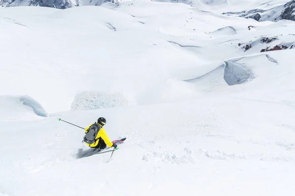 Een skiër op snelheid rijdt op een besneeuwde helling freeride. Het concept van winter extreme sporten — Stockfoto