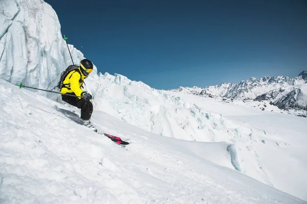 Een skiër op snelheid rijdt op een besneeuwde helling freeride. Het concept van winter extreme sporten — Stockfoto