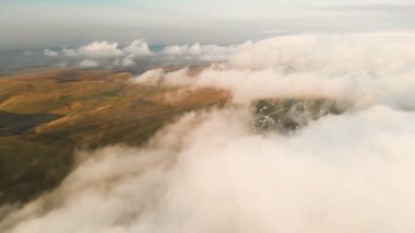 Uçan alacakaranlıkta veya şafakta bulutlar üzerinde. Bulutların üstünde uçan. Havadan görünümü. Kuzey Kafkasya