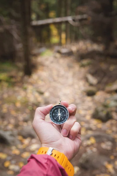 Krásné mužské ruce s žluté hodinky popruh má magnetický kompas v jehličnatých podzimním lese. Koncept nalezení sebe sama, cesta a pravda — Stock fotografie