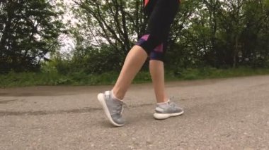 Ormanda koşu önce ince kız yakın çekim bacaklar. Düşük açılı hareket nesnenin çevresinde