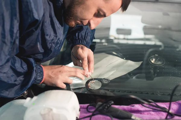 Närbild av Automobile glasmästare arbetare fastställande och reparera vindrutan eller vindrutan på en bil i auto service station garage — Stockfoto