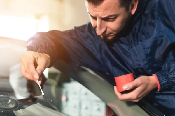 Närbild av Automobile glasmästare arbetare fastställande och reparera vindrutan eller vindrutan på en bil i auto service station garage — Stockfoto