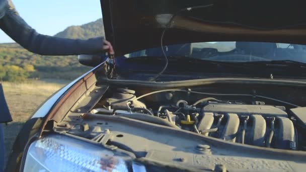 Dívka se otevře kryt nádrže sklo podložka pod kapotou svého auta — Stock video