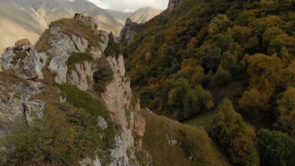 Chegem 峡谷で鋭い岩の眺め.ロシアのカバルダ ・ バルカル共和国。秋の夏。鋭い岩の夕日の光線近く空中パノラマ — ストック動画
