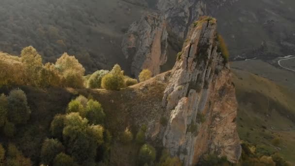 Vista aérea de la roca afilada en la garganta de Chegem. Kabardino-Balkaria República de Rusia. Verano otoñal. Panorama aéreo cerca de la roca afilada rayos del atardecer — Vídeos de Stock