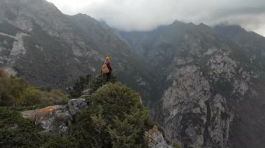 Şapkalı kız fotoğrafçı sarışın dağlarda bir kamera ile yürür. Chegem gorge Kuzey Kafkasya