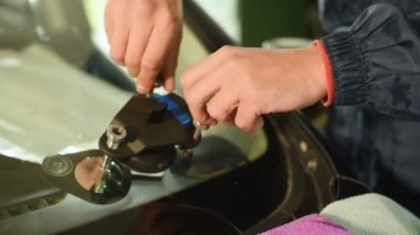 Bir erkekte profesyonel atölye Close-up arabanın ön cam üzerinde çatlaklar giderilmesinde nişanlı. Vakum dolgu işi