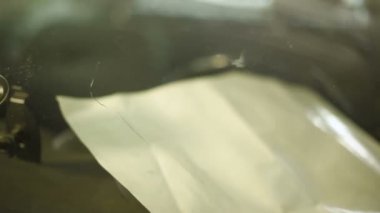 Bir erkekte profesyonel atölye Close-up arabanın ön cam üzerinde çatlaklar giderilmesinde nişanlı. Belgili tanımlık çatlamak polimer ile doldurma