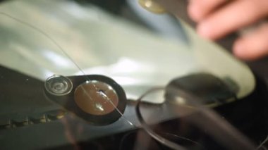 Bir erkekte profesyonel atölye Close-up arabanın ön cam üzerinde çatlaklar giderilmesinde nişanlı. Polimer UV kurutma