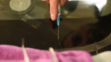 Bir erkekte profesyonel atölye Close-up arabanın ön cam üzerinde çatlaklar giderilmesinde nişanlı. Belgili tanımlık çatlamak polimer ile doldurma