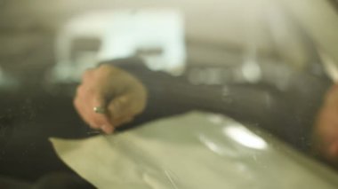 Bir erkekte profesyonel atölye Close-up arabanın ön cam üzerinde çatlaklar giderilmesinde nişanlı. Belgili tanımlık çatlamak polimer ile doldurma