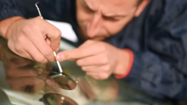 Close-up of a man professionally in the workshop engaged in eliminating cracks on the windshield of the car. Filling the crack with polymer — Stock Video