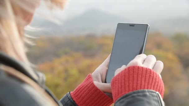 Närbild Ots blondinen med fingrar på sin smartphone. Flicka innehav smartphone — Stockvideo