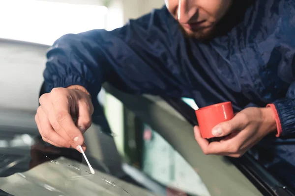 Närbild av Automobile glasmästare arbetare fastställande och reparera vindrutan eller vindrutan på en bil i auto service station garage — Stockfoto