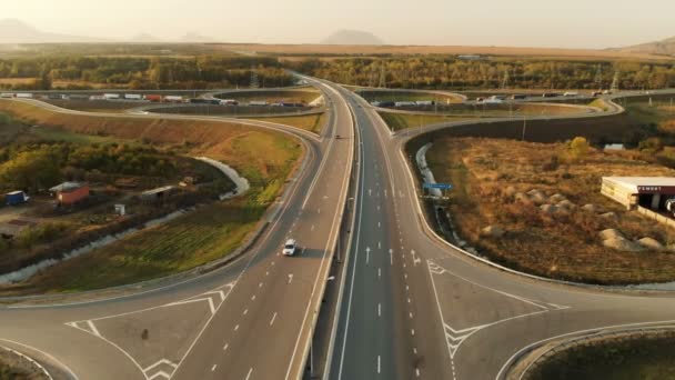 Luftaufnahme. Autobahn und Überführung mit Autos und Lastwagen. Die Straßenkreuzung ist eine zweistufige Straßenkreuzung außerhalb der Stadt. Blick von oben — Stockvideo