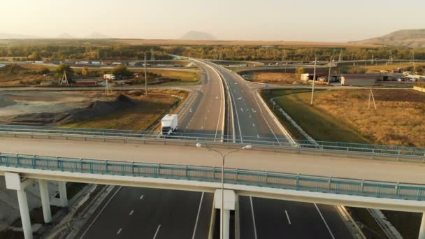 Luftaufnahme. Autobahn und Überführung mit Autos und Lastwagen. Die Straßenkreuzung ist eine zweistufige Straßenkreuzung außerhalb der Stadt. Blick von oben — Stockvideo