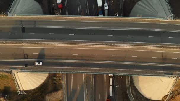 Вид с воздуха. Шоссе и эстакада с автомобилями и грузовиками. Дорожный узел является двухуровневым дорожным узлом за пределами города. Вид сверху — стоковое видео