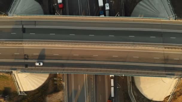 Vue aérienne. Autoroute et passage supérieur avec des voitures et des camions. Le carrefour routier est un carrefour routier à deux niveaux à l'extérieur de la ville. Vue d'en haut — Video