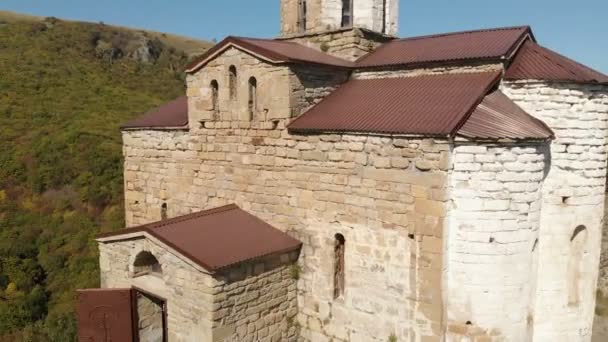 4K UHD Vista aerea di un monastero di montagna in piedi su una scogliera. Antico tempio cristiano del X secolo situato a Karachay-Cherkessia. Russia. Caucaso settentrionale — Video Stock